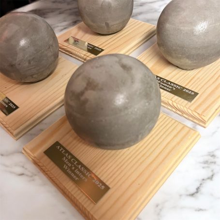 Four grey, spherical awards placed on wooden bases with engraved plaques.